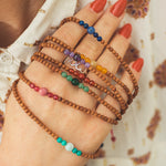 Chakra Armbänder aus Sandelholz und Halbedelstein Perlen mit Makramee Verschluss.