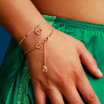 Frau trägt ein Münzarmand und Kleeblatt Armband in Roségold.