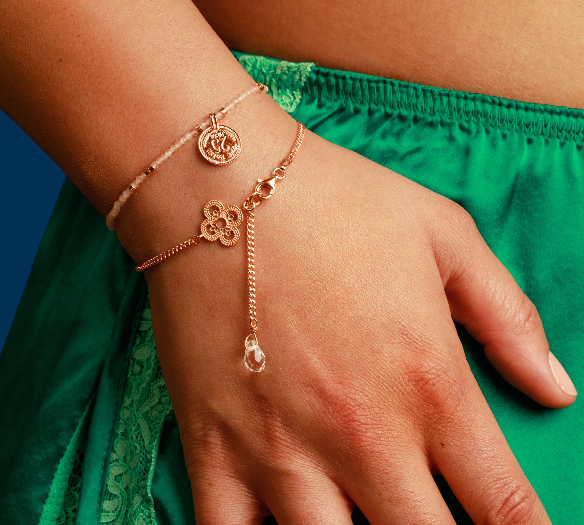 Frau trägt ein Münzarmand und Kleeblatt Armband in Roségold.