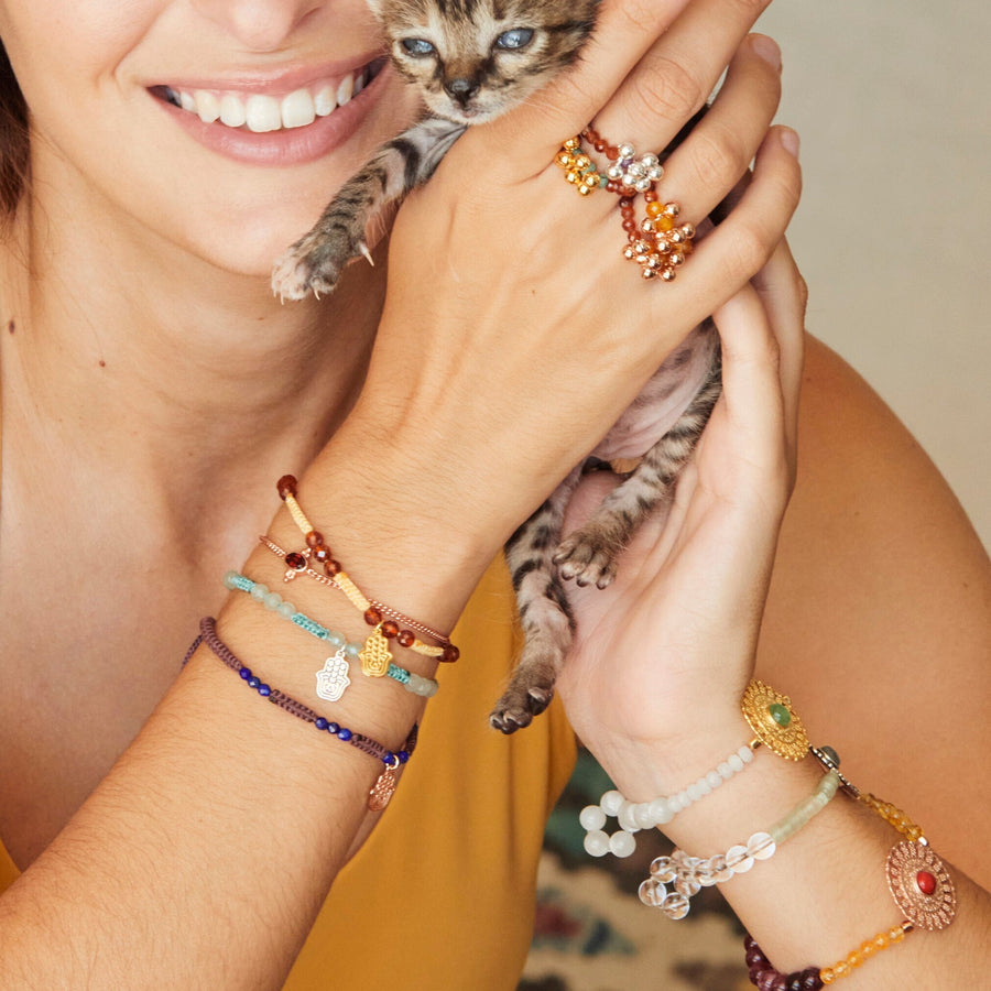 Größenverstellbares Makramee Armband mit echten Granat Edelsteinen und vergoldeter Hamsa Hand.
