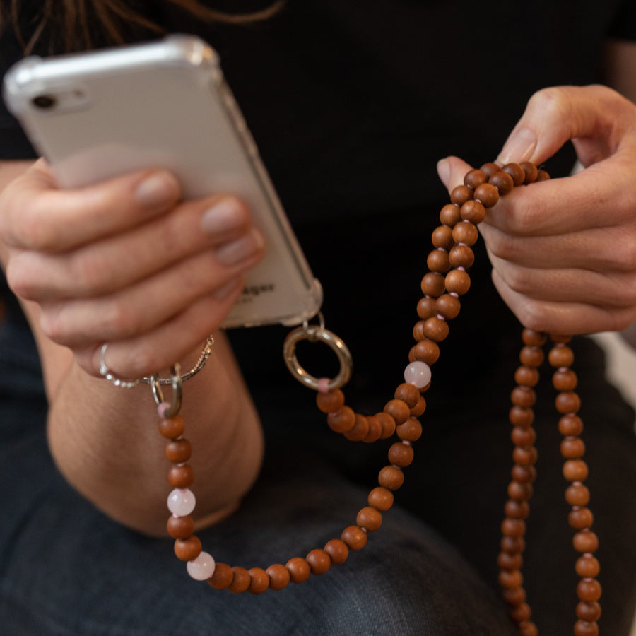 Frau hält hoffnungsträger Handykette Perlen mit iphone 