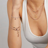 Frau mit Layering Schmuck und Gliederarmband in Roségold mit Mondstein Anhänger