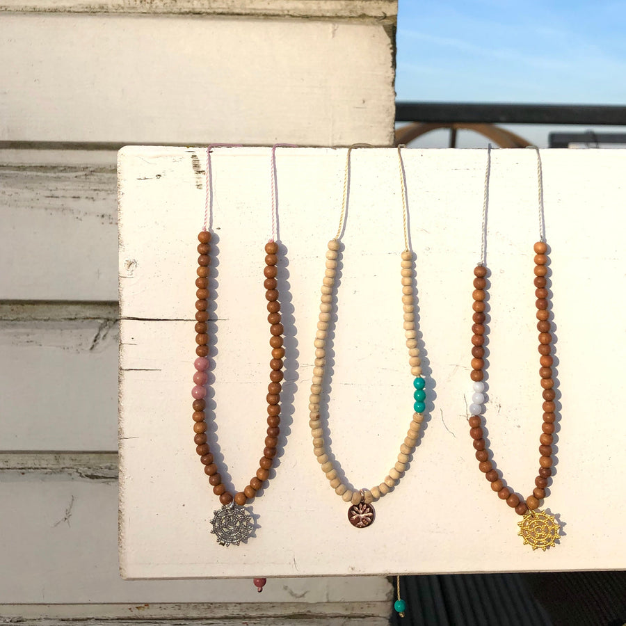 Längenverstellbare Sandelholz Choker Ketten mit Wheel of Karma Anhängern.