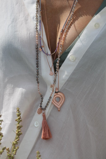 Edelsteinkette mit rosa Quaste und Glücksbringer Wheel of Karma Anhänger.