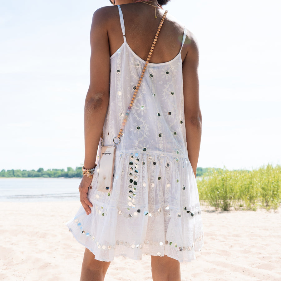 Frau im Sommerkleid mit langer Handykette aus Perlen und Handy