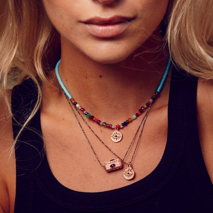 Frau mit hoffnungsträger Choker Kette in hellblau, bunten Steinen und Auge Anhänger in Rosegold