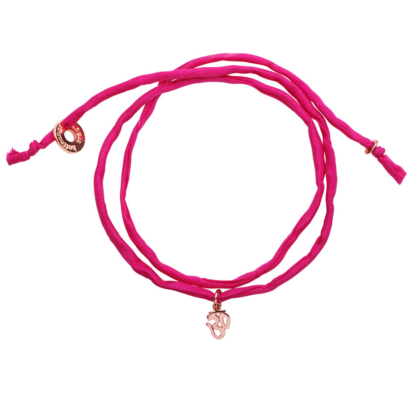 Pinkes Seidenarmband mit roségoldenem OM Anhänger als Wickelarmband.