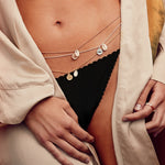Bauchkette aus Sterlingsilber mit Muschel und Auge Anhänger an Frau im Bikini